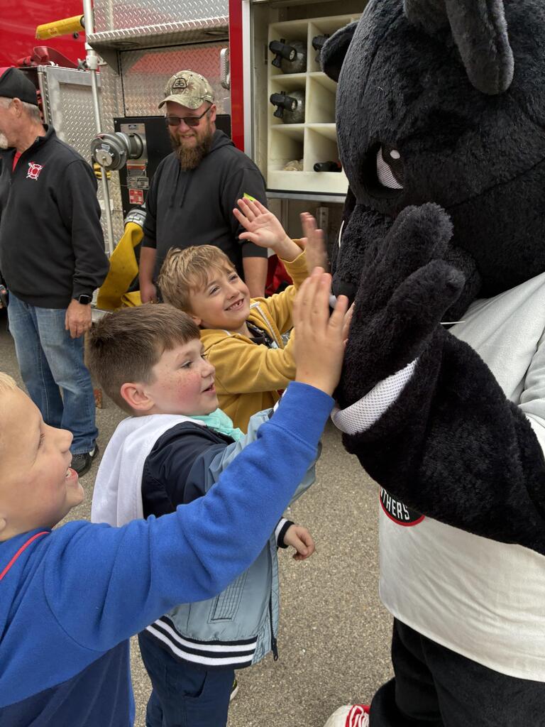 Students giving the Panther high fives outside the firetruck.