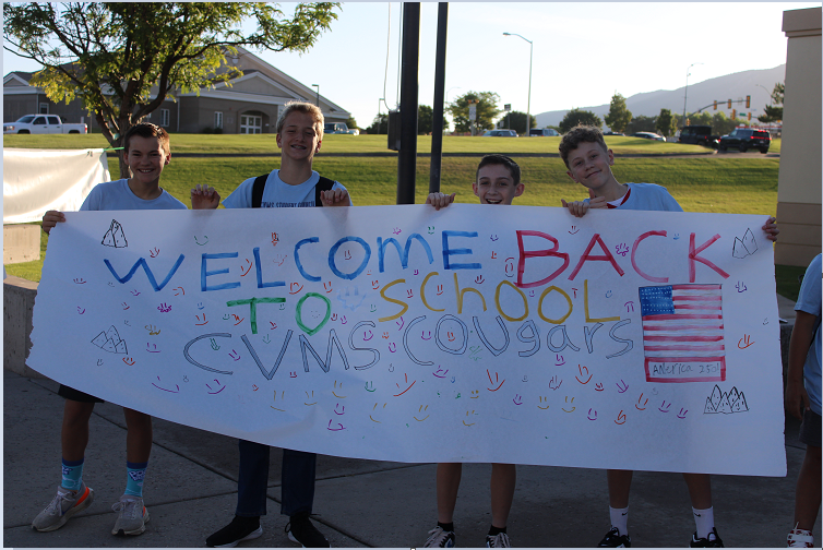 students  holding up welcome back to school sign
