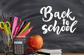 black board with back to school written in chalk and a shopping cart full of school supplies along with an apple sitting on a counter