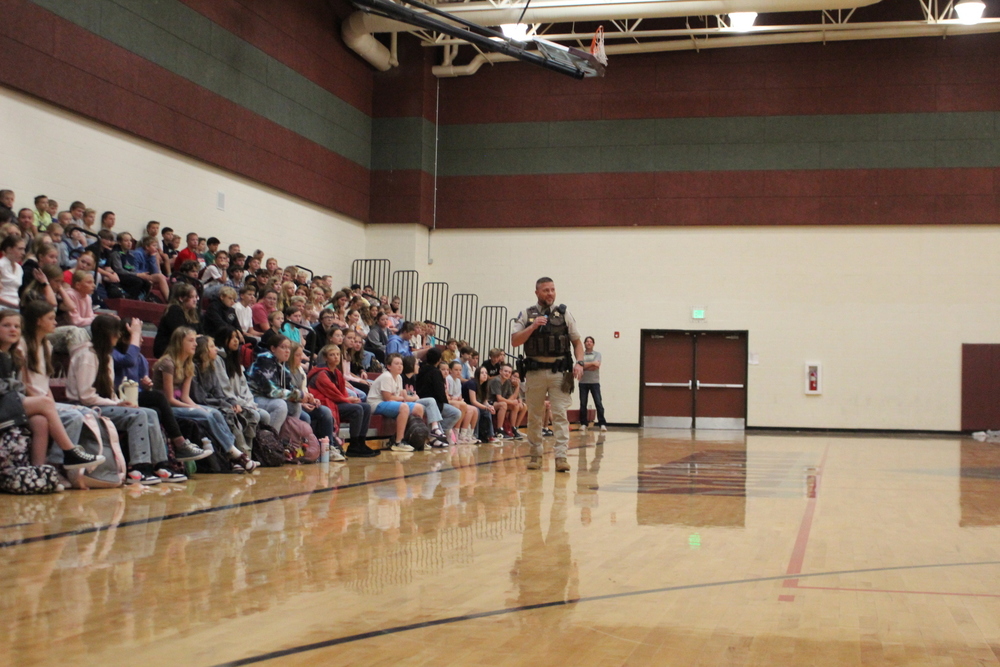 Officer talking to student in a gym