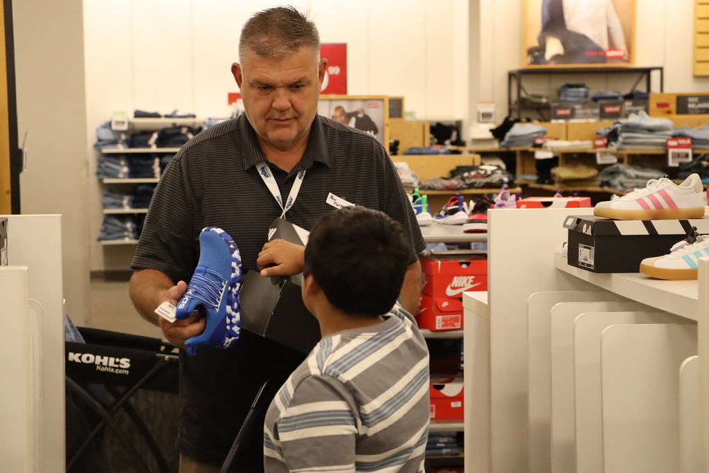 A volunteer shows the student a. possible shoe.