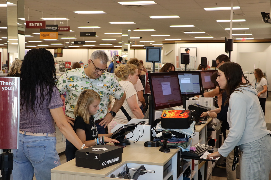 Students and volunteers pay for their shopping bag full of clothes.
