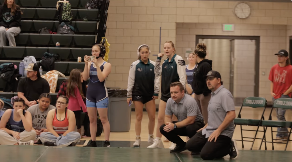 Travis Carter and Clay Allred watch a wrestling match.