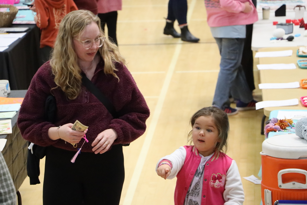A mother and daughter walk through the Makers Market,