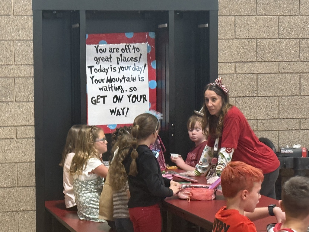 Signs with Dr. Seuss quotes decorate the lunchroom where students are enjoying lunch.