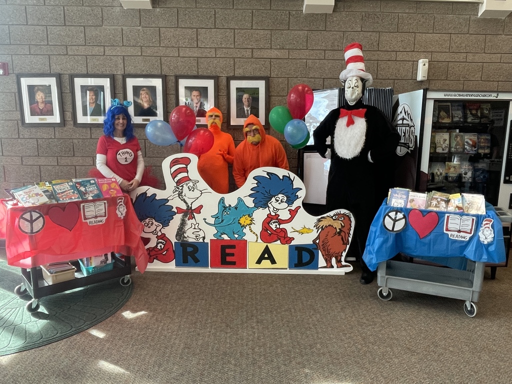 Teachers pose with their carts of books before delivering one to each child.