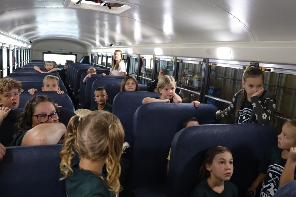 Students listen as they sit on the bus.