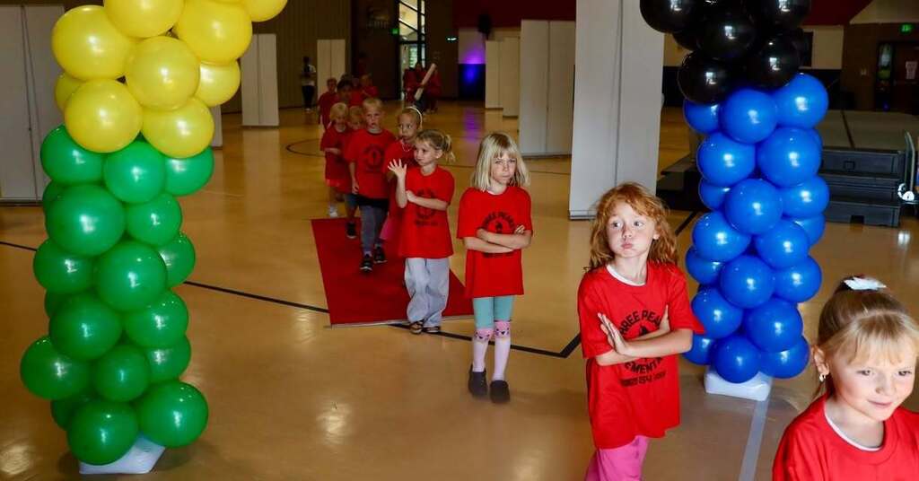 Students walk under a balloon arch.