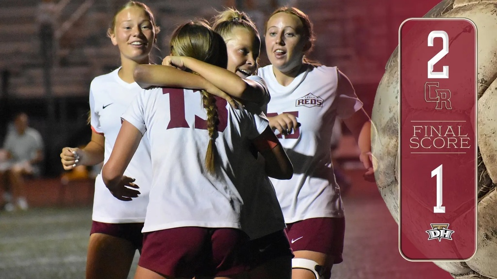 soccer players hug after scoring a goal