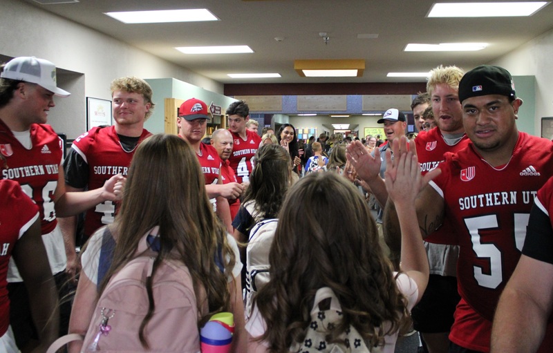 Students greeted by football players