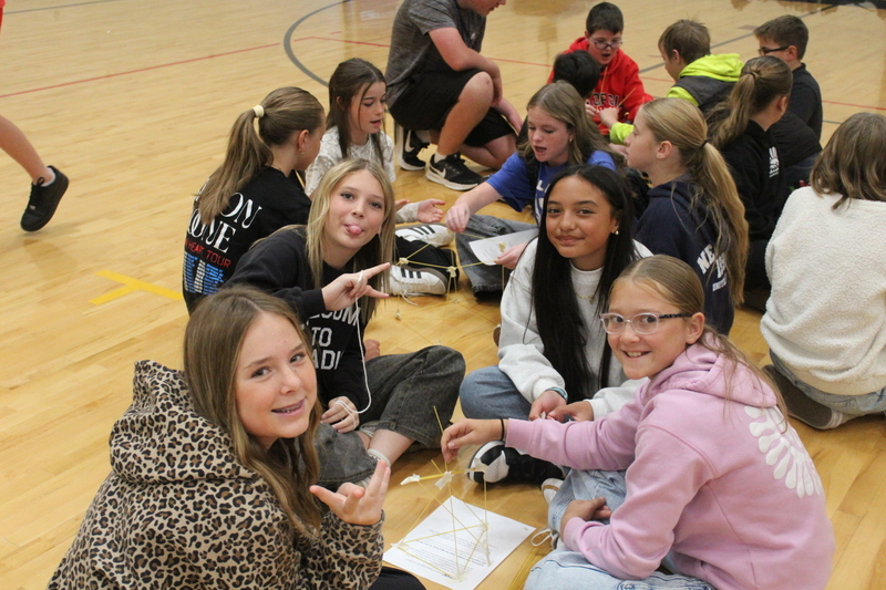 students sitting on gym floor