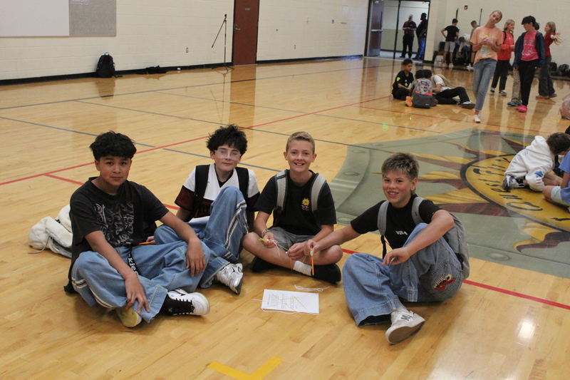 students sitting on gym floor