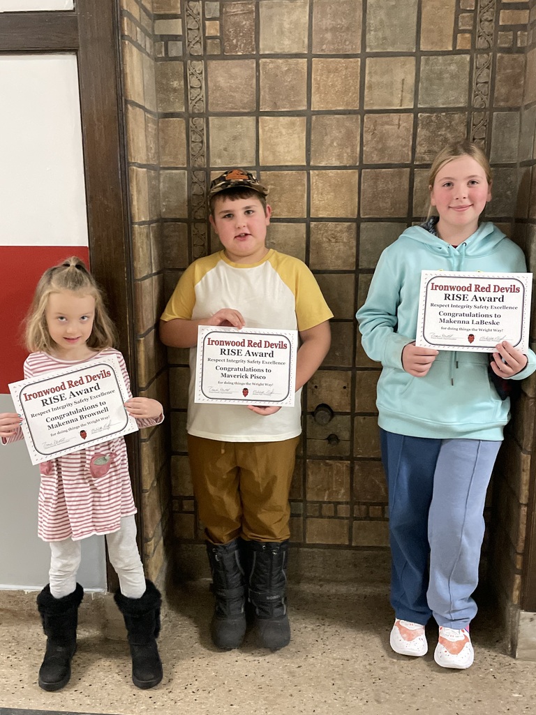 Three students hold up Student of the Month certificates