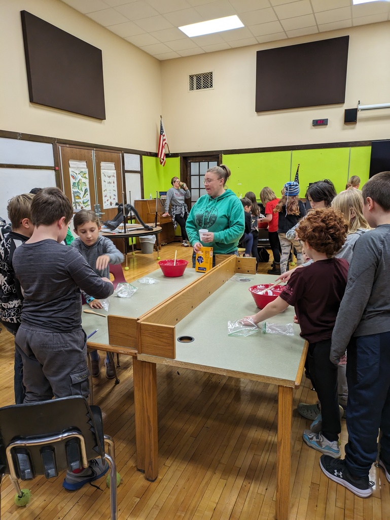 Students work with large red bowls at tables