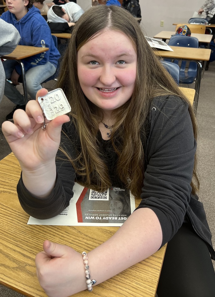 A student shows off her keychain and paper