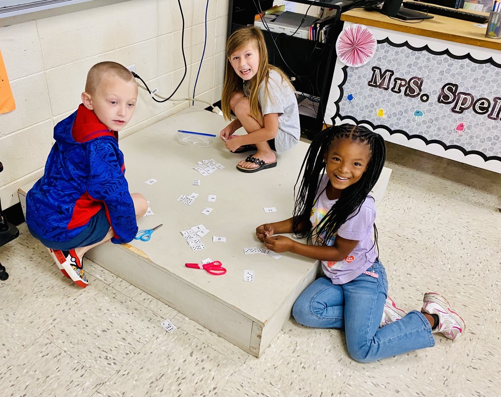 students worked in groups using domino cutouts to explore number combinations