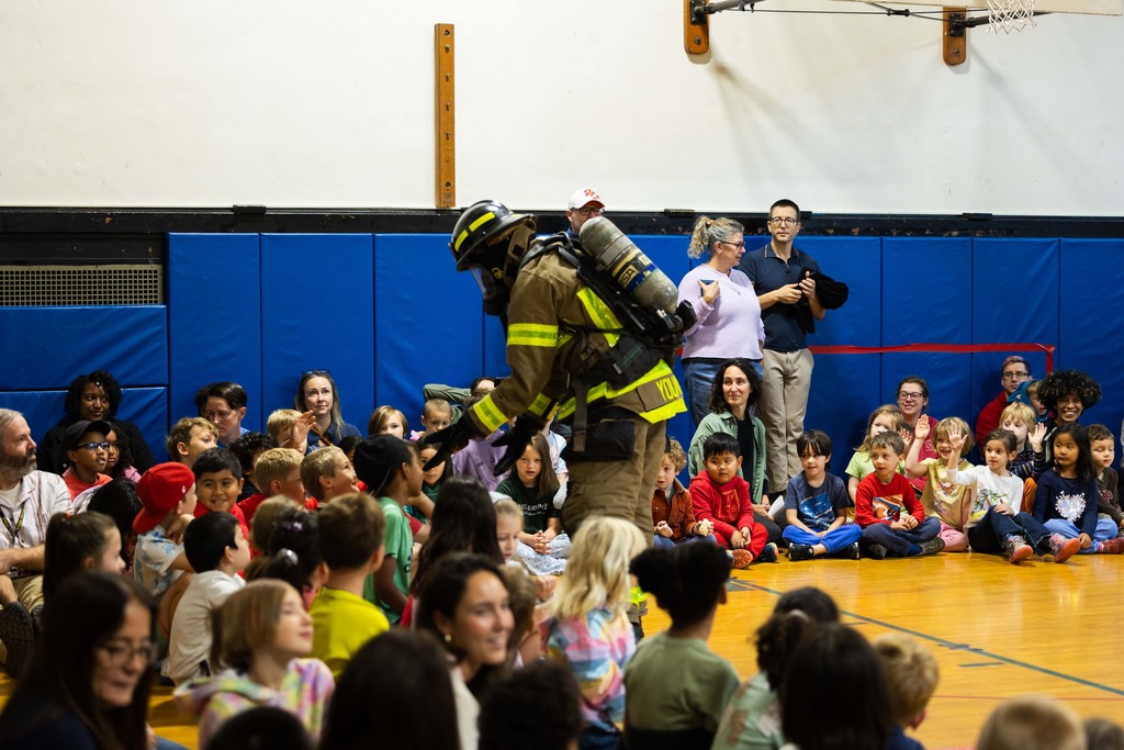 Firefighter interacting with students inside the gym