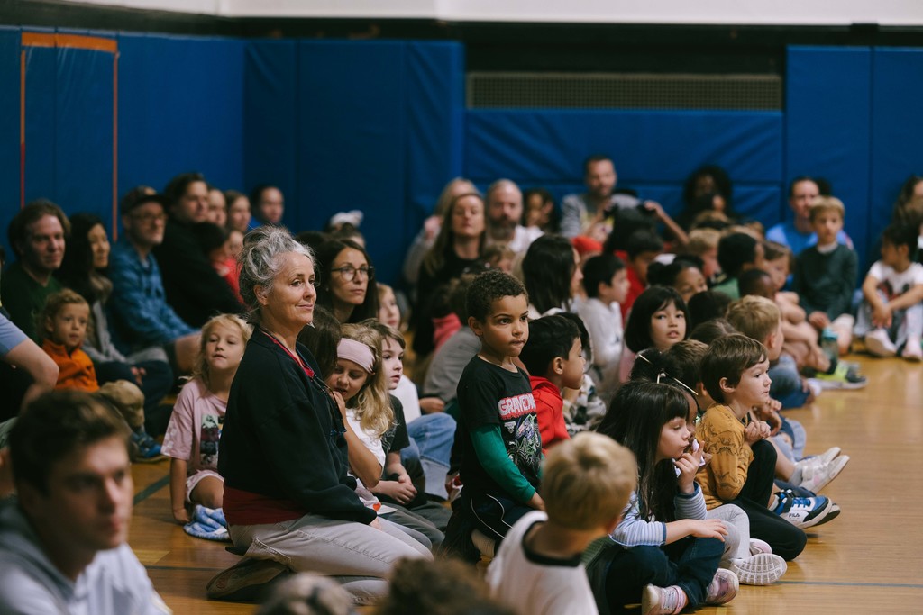 Students sitting on the gym floor 