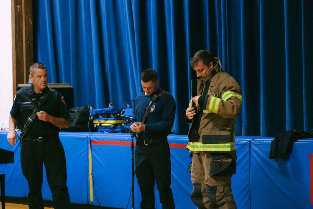 Three firefighters inside the gym at Fall Creek