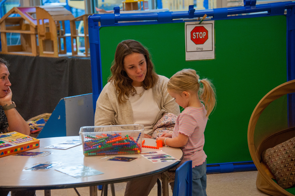 A mom staring at her child at a small desk