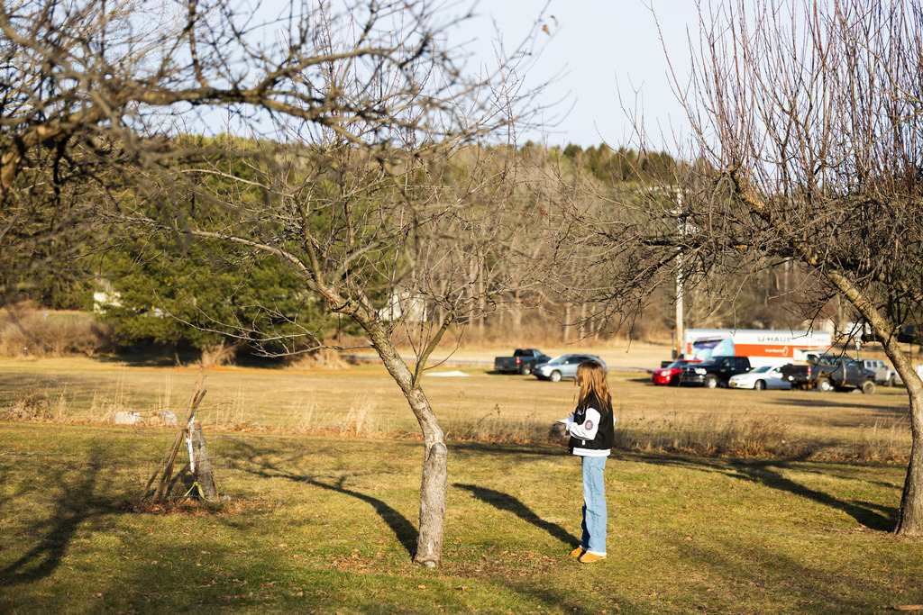 Enfield student outside in the orchard looking up at the sky. 