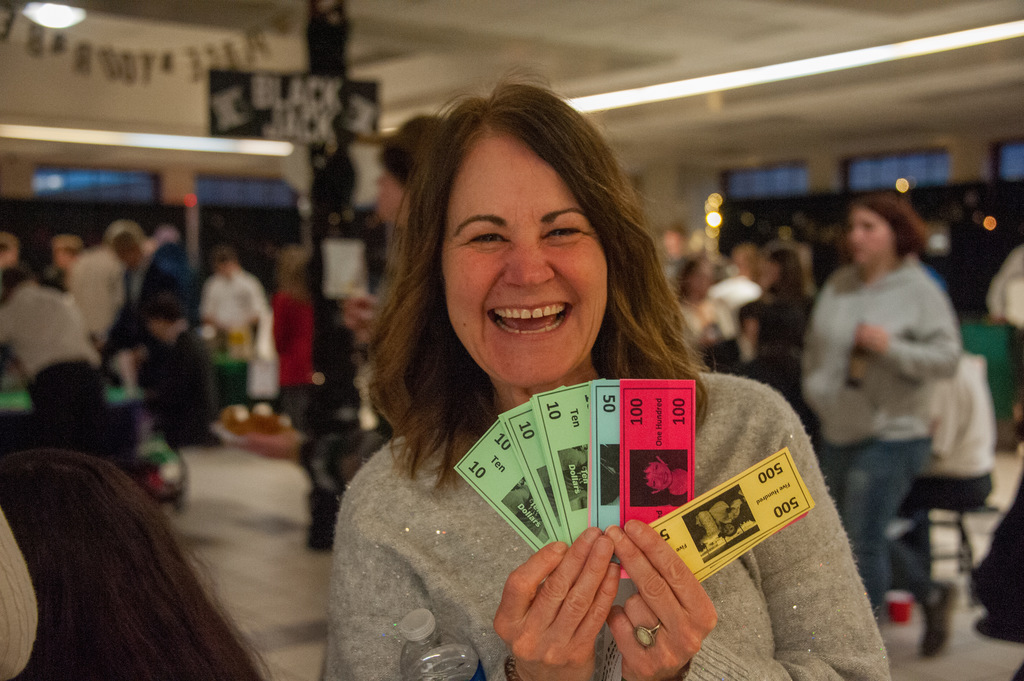IHS principal Caren Arnold holding colorful tickets at casino night