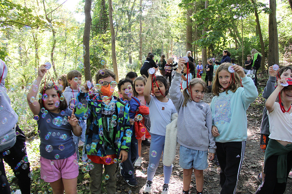 Several children with medals pose around bubbles on the rec trail
