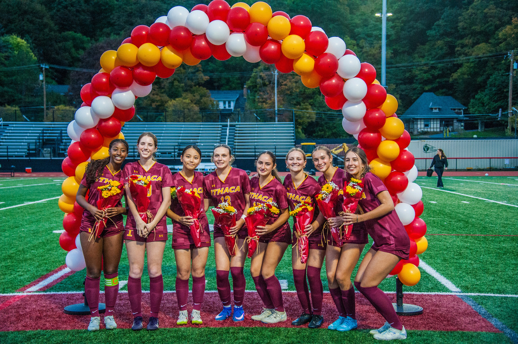 Seniors on the girls soccer team pose in front of a balloon arch