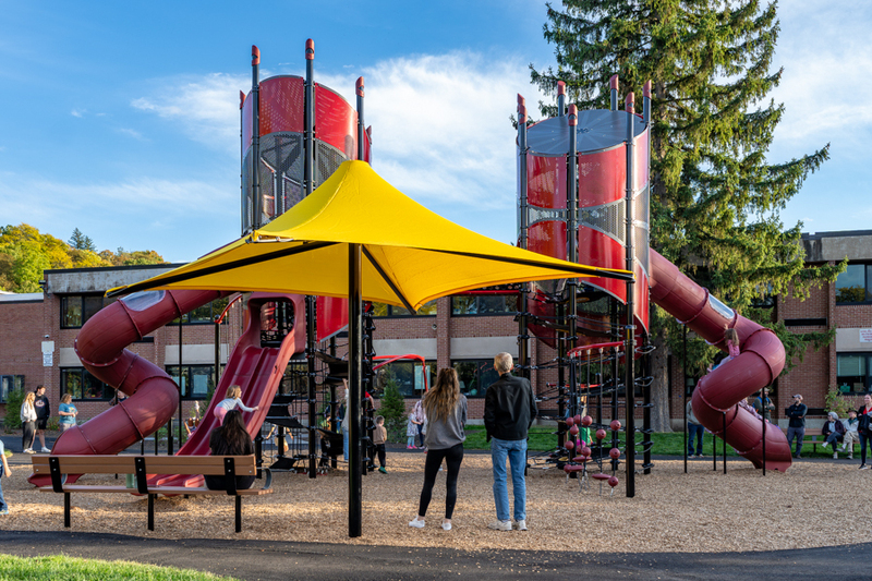 Two parents stand in front of a new playground