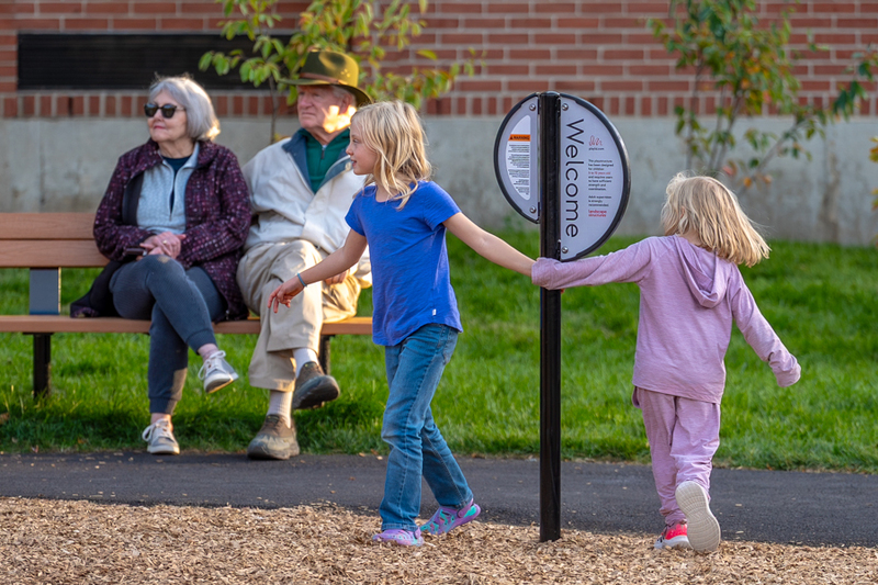 Two student circle around a sign