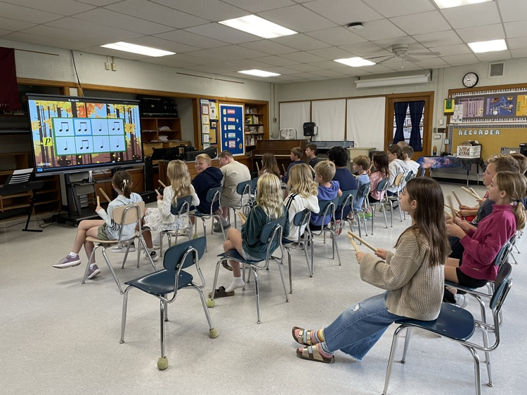 students playing rhythm sticks