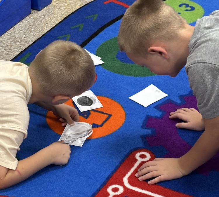students with magnifying lenses