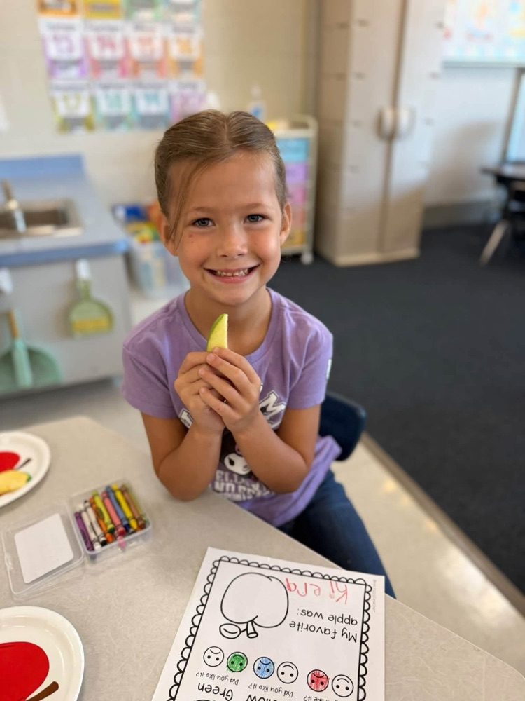 student with apple slice