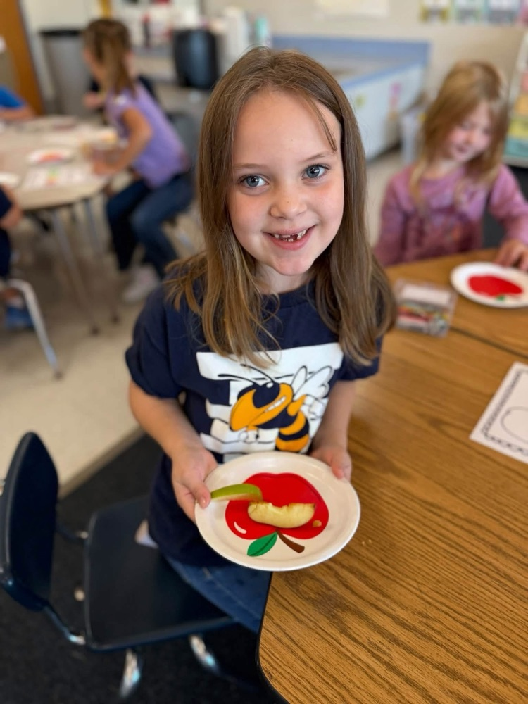 student with apple slice 