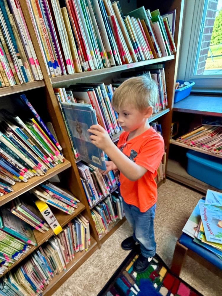child checking out a book