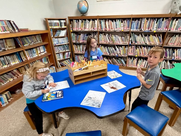 children coloring at a table 