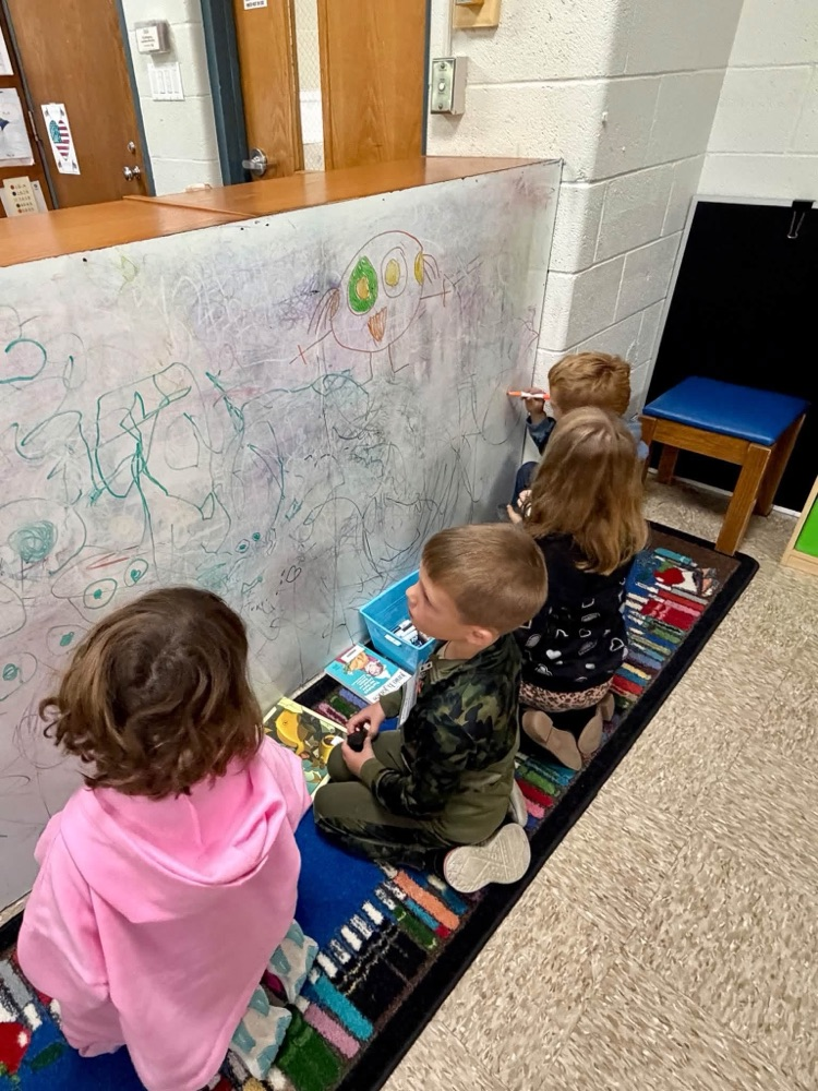children drawing on a board 
