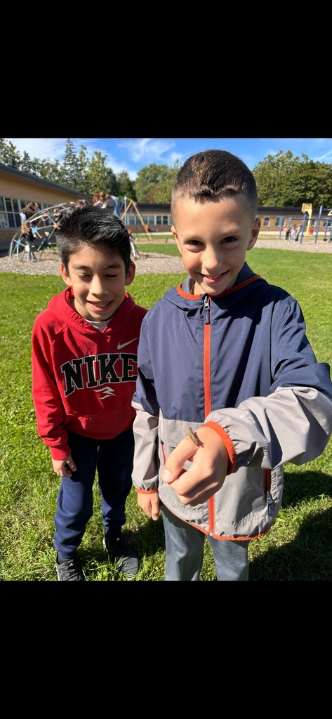 4th graders holding a grasshopper they found at recess