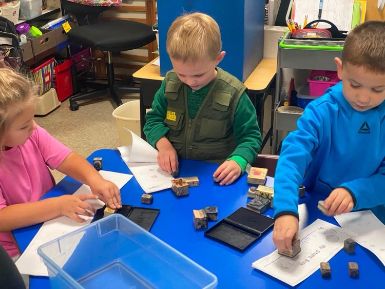students with paper and ink pads and stamps