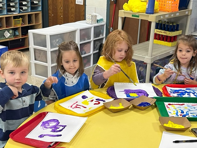 students painting at a table
