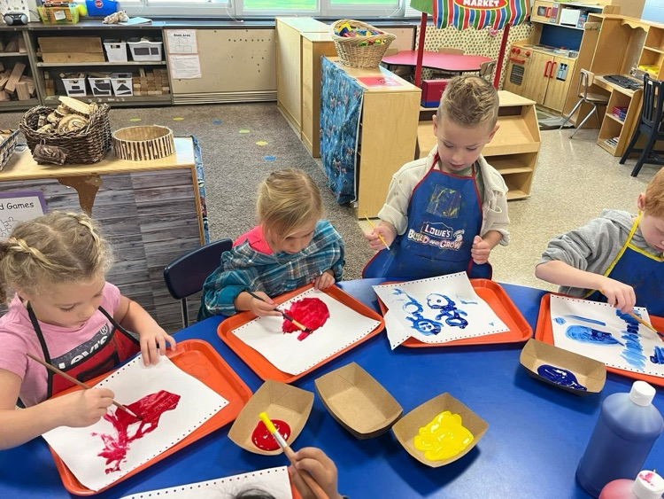 students painting at a table