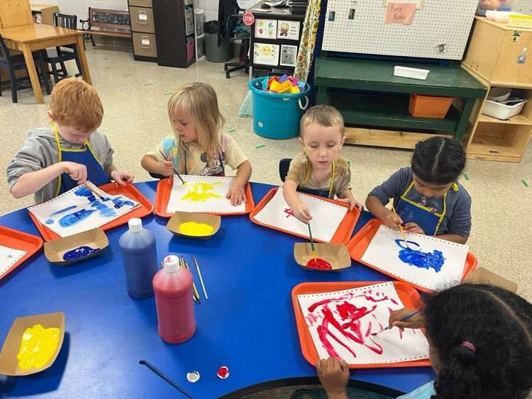 students painting at a table