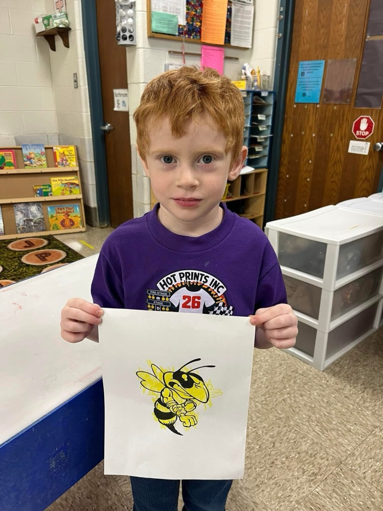 student holding a picture of a Yellowjacket
