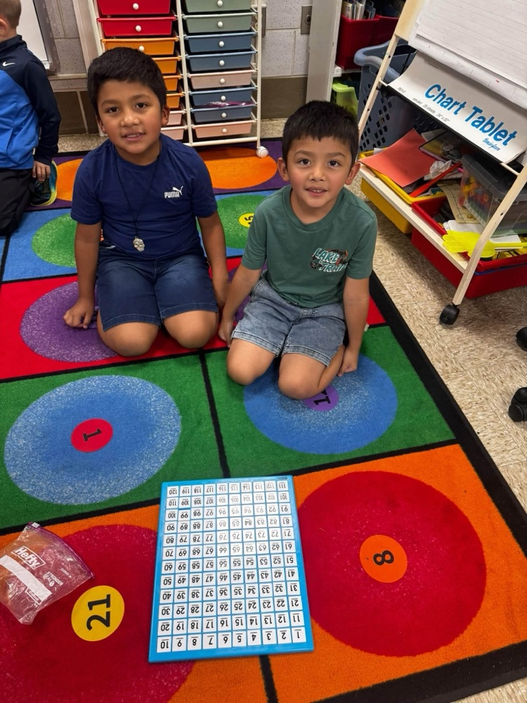 students on a rug showing a puzzle