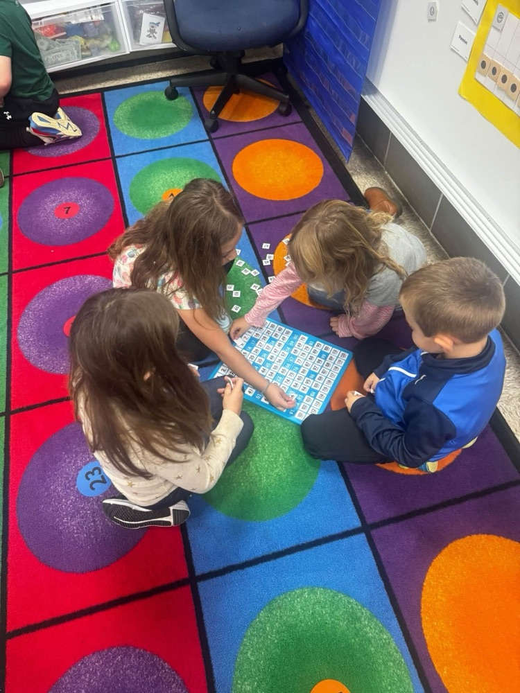 students working together on the rug to solve a puzzle