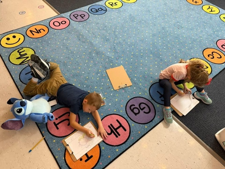 students at the carpet with their stuffies