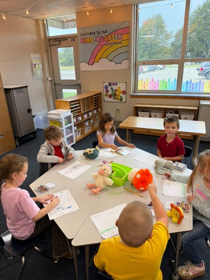 students work at the table with their stuffies