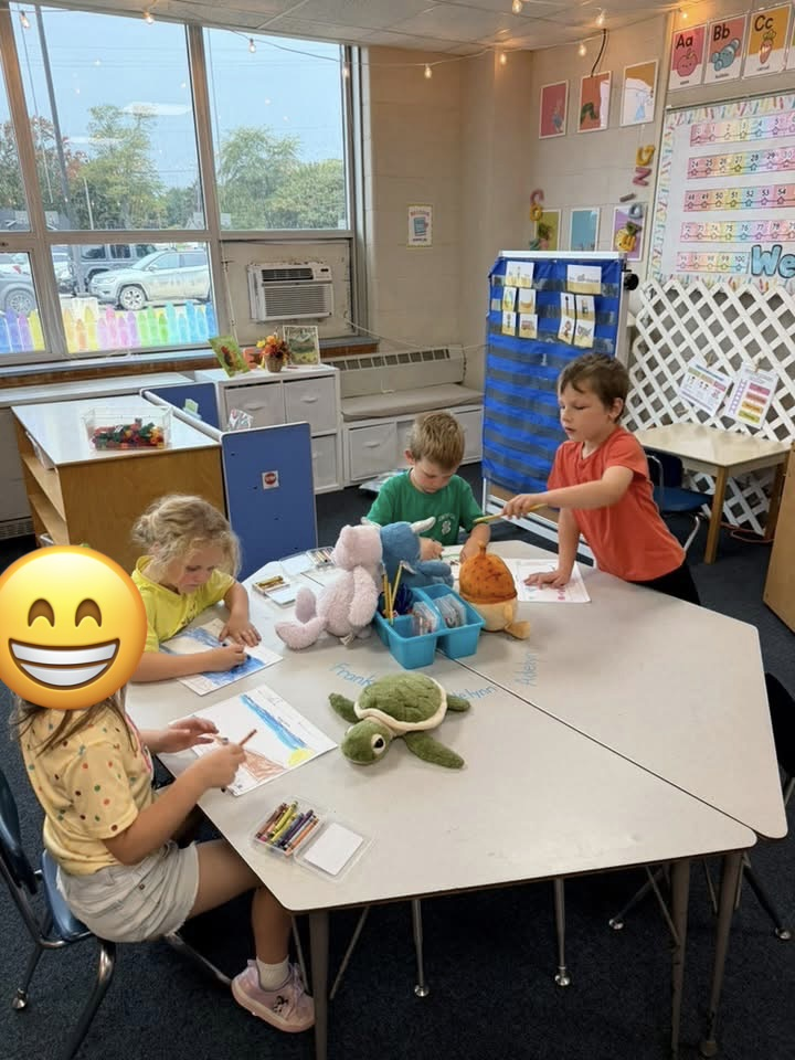 students work at the table with their stuffies