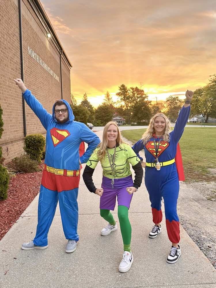Three staff members dressed up as superheroes.
