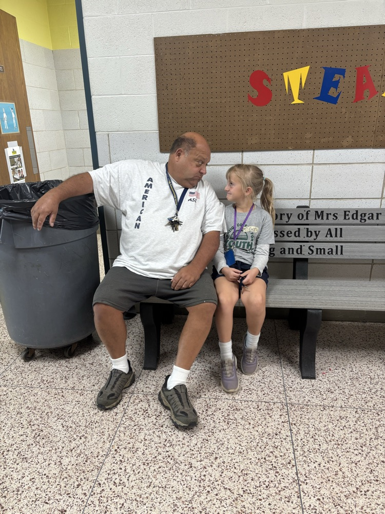 student and staff member making a silly face at each other.
